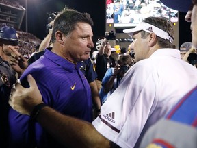 Mississippi State head football coach Dan Mullen confers with LSU head football coach Ed Orgeron following their NCAA college football game against in Starkville, Miss., Saturday, Sept. 16, 2017. Mississippi State won 37-7. (AP Photo/Rogelio V. Solis)