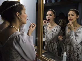 In this Friday, Sept. 15, 2017 photo, ballet dancers from Uruguay's National ballet of the Sodre put on lipstick before a dress rehearsal for Romeo and Juliet in Montevideo, Uruguay. Dancers practice Monday through Friday for eight hours at a time. (AP Photo/Matilde Campodonico)
