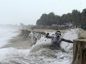 A man fights against waves caused by approaching Hurricane Max that took away part of the beach in Pie de La Cuesta, on the outskirts of Acapulco, Guerrero state, Thursday, Sept. 14, 2017. Max has strengthened into a Category 1 hurricane off Mexico's southern Pacific coast and is forecast to make landfall later Thursday along the coast of Guerrero state. It's a region that includes the resort city of Acapulco. (AP Photo/Bernandino Hernandez)