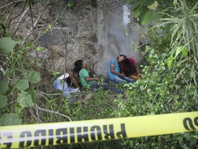EDS NOTE: GRAPHIC CONTENT - The bodies of four men, two of them teenagers, lie against a wall under an overpass on a highway after being shot in the town of Coyuca, near Acapulco, Guerrero state, Mexico, Tuesday, Sept. 12, 2017. The position of the bodies suggested they were lined up and shot, according the Guerrero state security spokesman Roberto Alvarez. (AP Photo/Bernandino Hernandez)