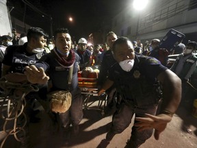 An injured person is carried after being rescued from the rubble of a building that collapsed after an earthquake, in the Colonia Obrera neighborhood of Mexico City, Tuesday, Sept. 19, 2017. A magnitude 7.1 earthquake has stunned central Mexico, killing at least more than 100 people as buildings collapsed in plumes of dust. Thousands fled into the streets in panic, and many stayed to help rescue those trapped. (AP Photo/Miguel Tovar)