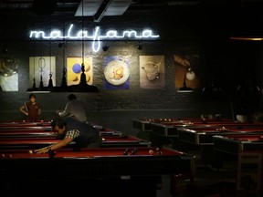 Locals play pool at a venue in Mexico City's La Condesa neighborhood, Friday, Sept. 22, 2017, four days after the 7.1 earthquake. The upscale Mexico City neighborhood was one of the hardest hit, with more than a half-dozen collapsed buildings in the immediate vicinity. The few Condesa residents who ventured out Friday night said they were anxious for relief from an anguishing week. (AP Photo/Nico Gonzalez)