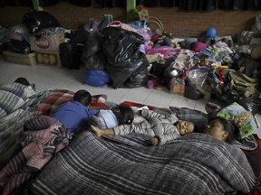 Florencia Cortes, 37, right, sleeps next to her son Jonatan at the Francisco Kino school, which was turned into a temporary shelter for residents evacuated from the large apartment complex in the Tlalpan neighborhood of Mexico City, Monday, Sept. 25, 2017.  Cortes was pulled from the rubble of her apartment building along with her 1-year, 8 months-old son, Jonatan. In order to get her son out, she had to swing him toward the building's plumber, who happened to be outside. He caught ahold of the boy by his foot. (AP Photo/Natacha Pisarenko)