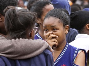 A student gestures as she stands with others, following a fire at the Moi Girls High School in Nairobi, Kenya Saturday, Sept. 2, 2017. Seven girls died early Saturday when a fire gutted their dormitory at a high school in Kenya's capital, Nairobi, the country's education minister said. The cause of the fire was unknown, Fred Matiangi said. Moi Girls High School will be closed for two weeks to allow for investigations. (AP Photo)