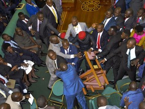 Ugandan lawmakers brawl in the Parliament in Kampala, Uganda Tuesday, Sept. 26, 2017. A fight broke out in Uganda's parliament Tuesday amid efforts to introduce legislation that could extend the president's decades-long hold on power. After opposition lawmakers accused some colleagues on the government side of carrying a gun, a brawl ensued in which lawmakers pushed and threw punches at each other. (AP Photo/Ronald Kabuubi)