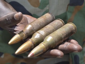 In this photo taken Saturday, Aug. 19, 2017, South Sudanese army commander Col. James Gatjiath holds ammunition captured from opposition fighters during recent clashes in Kuek, northern Upper Nile state, South Sudan. As the United States considers lifting sanctions on Sudan, one of the most sensitive issues is on display in these tense borderlands – weapons, which South Sudan's government accuses its neighbor of supplying to rebels fighting its bloody civil war. (AP Photo/Sam Mednick)