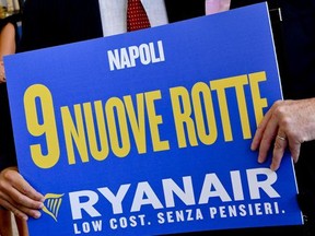 Ryanair CEO Michael O'Leary, right, kisses Armando Brunini, CEO of Gesac, Naples' airport managing company, as they hold up a poster publicizing nine new routes for Ryanair, at Capodichino airport, Italy, Wednesday, Sept. 6, 2017.  Reports say that O'Leary announced that the Irish low-cost carrier will make a binding offer for Alitalia but only for its long-haul sector. (Ciro Fusco/ANSA via AP)