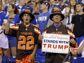 Cleveland Browns fans hold a sign following the national anthem before an NFL football game between the Indianapolis Colts and the Cleveland Browns in Indianapolis, Sunday, Sept. 24, 2017. (AP Photo/Michael Conroy)
