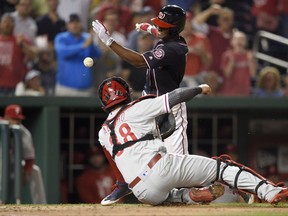 Washington Nationals' Michael Taylor, back, comes in to score against Philadelphia Phillies catcher Jorge Alfaro (38) on his inside-the-park grand slam during the third inning of a baseball game, Friday, Sept. 8, 2017, in Washington. (AP Photo/Nick Wass)