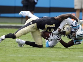 New Orleans Saints' Michael Thomas (13) is tackled after a catch by Carolina Panthers' Daryl Worley (26) in the first half of an NFL football game in Charlotte, N.C., Sunday, Sept. 24, 2017. (AP Photo/Mike McCarn)
