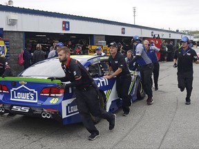 Jimmie Johnson's crew pushes their spare car to their garage during a practice session prior to qualifying for the NASCAR Cup Series auto race at New Hampshire Motor Speedway in Loudon, N.H., Friday, Sept. 22, 2017.  Johnson crashed his car during practice. (AP Photo/Charles Krupa)