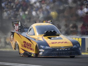 In this photo provided by the NHRA, J.R. Todd powers past Funny Car reigning world champion Ron Capps in his Dodge Charger in Indianapolis, Monday, Sept. 4, 2017. It is Todds first career win at the U.S. Nationals, his second of the season and of his Funny Car Career. (Jerry Foss/NHRA via AP)