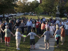 A chorus of "We Shall Overcome" rises from a gathering against racism in Broad Street Park in Claremont, N.H., Tuesday, Sept. 12, 2017. The demonstration was inspired by violence last month against an 8-year-old biracial boy that occurred while he played with a group of teenagers outside his home. (James M. Patterson/The Valley News via AP)