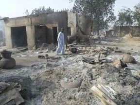 FILE - In this Sunday Jan. 31, 2016 file photo, a man walks past burnt out houses following an attacked by Boko Haram in Dalori village near Maiduguri. Nigeria-based Boko Haram extremists have killed more than 380 people in the Lake Chad region since April, a major resurgence of attacks that has resulted in double the casualties compared to the five months before April, Amnesty International said Tuesday, Sept. 5, 2017. (AP Photo/Jossy Ola, File)