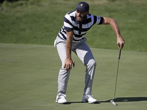 Dustin Johnson reacts to his putt on the ninth hole during the Presidents Cup foursomes golf matches at Liberty National Golf Club in Jersey City, N.J., Thursday, Sept. 28, 2017. (AP Photo/Julio Cortez)