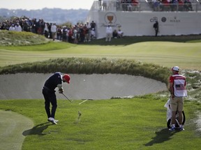 Dustin Johnson hits on the 13th green during the third day of the Presidents Cup at Liberty National Golf Club in Jersey City, N.J., Saturday, Sept. 30, 2017. (AP Photo/Julio Cortez)