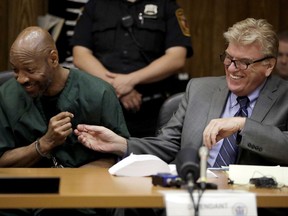 Eric Kelley, left, laughs with his attorney Paul Castelero after Passaic County Superior Court Judge Joseph Portelli granted Kelley a retrial in the case in which he was found guilty of the killing of a video store employee during a robbery in 1993, during a hearing, Friday, Sept. 15, 2017, in Paterson, N.J. Kelley and Ralph Lee, who was not present during the hearing, had been convicted and were currently serving terms. The new trials were granted after new DNA tests linked an important piece of evidence to another man. (AP Photo/Julio Cortez)