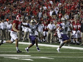 Washington wide receiver Dante Pettis (8) runs a punt-return for a touchdown as as Andre Baccellia (5) blocks Rutgers punter Ryan Anderson during the first half of an NCAA college football game Friday, Sept. 1, 2017, in Piscataway, N.J. (AP Photo/Mel Evans)