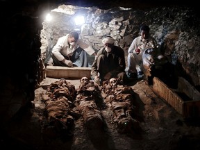 Archaeologists work on mummies found in the New Kingdom tomb that belongs to a royal goldsmith in a burial shaft, in Luxor, Egypt, Saturday, Sept. 9, 2017.