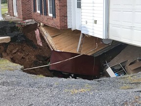 A sink hole swallows a two-storey home in Falmouth, N.S., Sunday, Sept.3, 2017. Officials say a family is safe after a sink hole opened up under a Nova Scotia home.