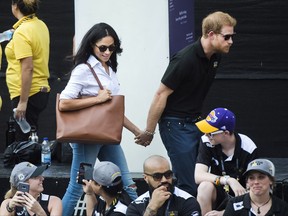 Prince Harry, right, arrives with his girlfriend Meghan Markle at the wheelchair tennis competition during the Invictus Games in Toronto on Monday, September 25, 2017. This is Prince Harry's first public appearance with Markle. THE CANADIAN PRESS/Nathan Denette