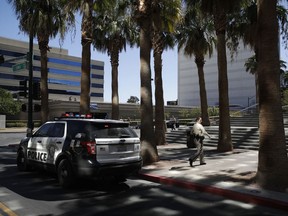 Police investigate a crime scene in front of the Regional Justice Center court house, Monday, Sept. 25, 2017, in Las Vegas. Police say a woman was struck by a car outside of the courthouse where she was the witness in a murder case. (AP Photo/John Locher)