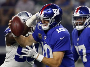 FILE - In this Sept. 10, 2017 file photo, Dallas Cowboys defensive end DeMarcus Lawrence (90) sacks New York Giants quarterback Eli Manning (10) in the first half of an NFL football game in Arlington, Texas. Manning felt the Cowboys' pass-rush wrath three times, but the issue for the Giants was that it's O-line was more of a 0-line, as in zero production.(AP Photo/Ron Jenkins)