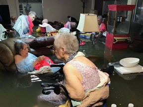 FILE - In this Aug. 27, 2017, file photo, provided by Trudy Lampson, residents of the La Vita Bella nursing home in Dickinson, Texas, sit in waist-deep flood waters caused by Hurricane Harvey. Authorities said all the residents were safely evacuated from the facility. Regulations dictate nursing homes and other facilities must have preparation plans in place for hurricanes, floods, tornadoes and other natural disasters, but the realities of how older Americans cope with a storm go beyond any piece of paper. The issue burst to the forefront again Wednesday, Sept. 12, 2017, with news of several deaths at the Rehabilitation Center at Hollywood Hills in Florida, where workers say Hurricane Irene caused the air conditioning to fail, and they struggled to keep residents cool with fans, cold towels and ice. (Trudy Lampson via AP, File)