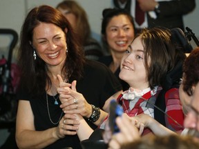 FILE - In this Monday, March 18, 2015 file photo, fourteen-year-old Jack Splitt, right, celebrates with his mother, Stacey Linn, as Colorado Governor John Hickenlooper signs a bill named after the young man from Wheat Ridge, Colo., to crack down on the state's medical marijuana industry in southeast Denver. Mark Pedersen, a man who made cannabis oil for Jack Splitt who was instrumental in passing a state law requiring schools to allow students to use medical marijuana is facing several felony drug charges.  (AP Photo/David Zalubowski, File)