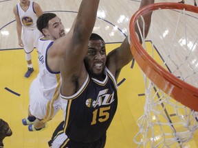 File-This Dec. 23, 2015, file photo shows Utah Jazz's Derrick Favors (15) going up for a dunk past Golden State Warriors' Klay Thompson during the first half of an NBA basketball game in Oakland, Calif.  Favors knows he's been the forgotten man in the Utah Jazz grand scheme. "I'm pretty much used to it," Favors said. "The whole time I've been here has been like that. It seems like everybody seems to forget about me all the time. That's what people kind of forget, I can score the ball, too, when I get the chance. "I definitely prepared myself this summer to be a big part of the offense, whether it's scoring or being a playmaker." (AP Photo/Marcio Jose Sanchez, File)