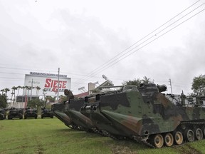 FILE - In this Sept. 10, 2017, file photo, National Guard amphibious vehicles stage at Raymond James Stadium in Tampa, Fla., as Hurricane Irma continues to churn towards the state. There will be football in Tampa this weekend, and the Buccaneers will finally get to start a season delayed by Hurricane Irma's wrath. The Bucs announced that they will be able to host the Chicago Bears on Sunday, Sept. 17, 2017 at Raymond James Stadium.(AP Photo/Chris O'Meara)