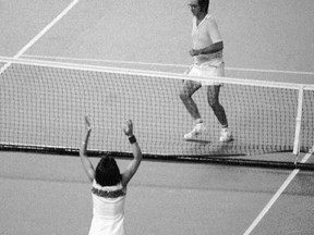 FILE - In this Sept. 20, 1973, file photo, Billie Jean King raises her arms after defeating Bobby Riggs, rear, getting ready to jump over the net, in the "Battle of the Sexes" tennis match at the Houston Astrodome. The story of the early days of the tour and King's fight for equal prize money is chronicled in the movie "Battle of the Sexes," which opened nationwide on Friday.  (AP Photo, File)