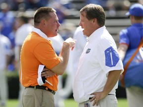 FILE - In this Sept. 26, 2015, file photo, Tennessee head coach Butch Jones, left, and Florida head coach Jim McElwain meet at midfield before an NCAA college football game between Florida and Tennessee in Gainesville, Fla. Two weeks after losing a season opener for the first time in 28 years, the Gators are facing the possibility of starting 0-2 for the first time since 1971 when they host Tennessee on Saturday. (AP Photo/John Raoux, File)