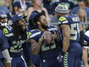 FILE - In this Aug. 25, 2017, file photo, Seattle Seahawks cornerback Richard Sherman, free safety Earl Thomas, center, and middle linebacker Bobby Wagner (54) react on the sideline during the second half of an NFL football preseason game against the Kansas City Chiefs, in Seattle. Thomas appears to be fully recovered from the injury that sidelined the safety late last season. The free safety is such a key cog in Seattle because of an ability to cover so much ground in the defensive backfield. (AP Photo/John Froschauer, File)