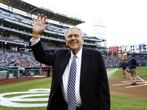 FILE - In this April 26, 2013, file photo, former Washington Senators broadcaster Bob Wolff waves to the crowd during a ceremony before a baseball game between the Washington Nationals and the Cincinnati Reds at Nationals Park in Washington. The late Bob Wolff, one of the most prolific and recognizable voices in sports, will be honored with the Vin Scully Lifetime Achievement Award in Sports Broadcasting from Fordham University.  Wolff, who called the play-by-play in championship games in all four major team sports, died in July at the age of 96.(AP Photo/Alex Brandon, File)