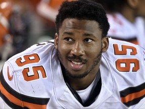 FILE - In this Aug. 10, 2017, file photo, Cleveland Browns defensive end Myles Garrett sits on the bench during the first half of an NFL preseason football game against the New Orleans Saints in Cleveland. Garrett, the No. 1 overall pick in this year's NFL draft, is back practicing after missing Cleveland's first three games with a sprained right ankle. Garrett has been out since Sept. 6, when he hurt his ankle when a teammate fell on it.  (AP Photo/David Richard, File)