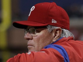In this Aug. 17, 2017 photo, Philadelphia Phillies manager Pete Mackanin watches from the dugout before a baseball game against the San Francisco Giants in San Francisco. The Phillies announced Friday, Sept. 29, 2017, that Mackanin will be replaced for next season. (AP Photo/Jeff Chiu, File)