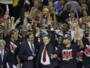 FILE - In this April 8, 2013, file photo, Louisville players and head coach Rick Pitino celebrate after defeating Michigan 82-76 in the championship of the Final Four in the NCAA college basketball tournament in Atlanta. Louisville announced Wednesday, Sept. 27, 2017, that they have placed basketball coach Rick Pitino and athletic director Tom Jurich on administrative leave amid an FBI probe. (AP Photo/Chris O'Meara, File)