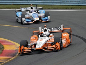 FILE - In this Sept. 3, 2017, file photo, Josef Newgarden (2) leads Scott Dixon (9) through Turn 11 during an IndyCar Series auto race, in Watkins Glen, N.Y. As NASCAR prepares to open its playoffs, the IndyCar Series is ready to crown its champion. Four drivers go into the season finale Sunday at Sonoma Raceway in contention for the title, which is a Penske vs. Ganassi showdown. Josef Newgarden holds a three-point lead in the standings over Ganassi driver Scott Dixon. Newgarden's two Penske teammates are also in striking distance. (AP Photo/Matt Slocum, File)