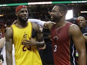 FILE - In this Dec. 25, 2014, file photo, Cleveland Cavaliers forward LeBron James (23) and Miami Heat guard Dwyane Wade talk following an NBA basketball game in Miami. Wade is expected to sign Wednesday, Sept. 27, 2017, with the Cavaliers, reuniting the 12-time All-Star with James, a former Miami teammate and one of his best friends.  (AP Photo/Lynne Sladky, File)