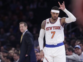 FILE - In this April 4, 2017, file photo, New York Knicks' Carmelo Anthony (7) checks in as coach Jeff Hornacek, left, watches during the first half of an NBA basketball game against the Chicago Bulls in New York. The Knicks said Friday, Sept. 22, 2017,  they expect Anthony will attend training camp when they report next week. (AP Photo/Frank Franklin II, File)