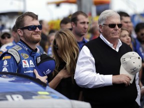 FILE - In this Feb. 21, 2016, file photo, Dale Earnhardt Jr, left, and team owner Rick Hendrick stand during the national anthem before the NASCAR Daytona 500 Sprint Cup Series auto race at Daytona International Speedway in Daytona Beach, Fla. Earnhardt Jr. said the views of two NASCAR team owners who said they would fire employees who do not stand for the national anthem does not speak for the sport. He said he hasn't discussed the issue with his teammates, crew or other employees at Hendrick Motorsports, but added that he will continue to stand for the anthem.  (AP Photo/Chuck Burton, File)