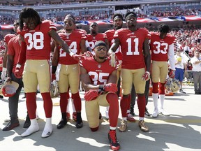 FILE - In this Sept. 10, 2017, file photo, San Francisco 49ers safety Eric Reid (35) kneels in front of teammates during the national anthem before an NFL football game against the Carolina Panthers in Santa Clara, Calif., Sunday. Reid was an early protester during the national anthem, joining former San Francisco teammate Colin Kaepernick last season.  (AP Photo/Marcio Jose Sanchez, File)