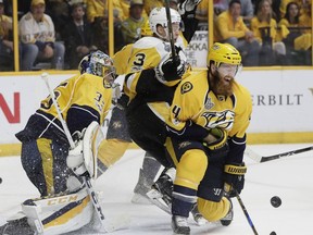 FILE - In this June 11, 2017, file photo, Nashville Predators' Ryan Ellis (4) and goalie Pekka Rinne (35), of Finland, defend the goal against Pittsburgh Penguins' Olli Maatta (3), of Finland, during the second period of Game 6 of the NHL hockey Stanley Cup Final, in Nashville, Tenn. Ryan Ellis will need a full six months to recover from offseason knee surgery, and general manager David Poile says they don't expect him back until possibly 2018. Poile gave an update on a couple injuries Thursday, Sept. 7, 2017, after a rookies' practice.  (AP Photo/Mark Humphrey, File)