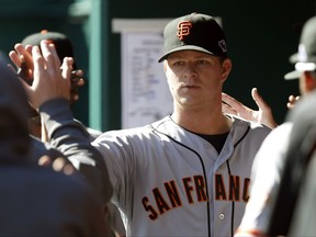 FILE - In this Oct. 11, 2012, file photo, San Francisco Giants starting pitcher Matt Cain is congratulated in the dugout after being taken out in the sixth inning of Game 5 of the National League division baseball series against the Cincinnati Reds in Cincinnati. Cain said Wednesday, Sept. 27, 2017, that he'll retire after his start at home on Saturday against San Diego. (AP Photo/David Kohl, File)