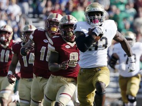 FILE - In this Saturday, Sept. 16, 2017, file photo, Notre Dame's Josh Adams (33) breaks away from Boston College defenders during the first half of an NCAA college football game in Boston.  The Irish are ranked No. 7 in the country in rushing at 293.5 yards per game and third nationally with 6.83 yards per carry. The offensive line has paved the way ever since a Sept. 9 loss to Georgia. Notre Dame hosts Miami of Ohio on Saturday. (AP Photo/Michael Dwyer)