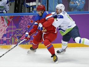 FILE - In this Feb. 13, 2014, file photo, Russia forward Alex Ovechkin, left, keeps the puck from Sovenia defenseman Matic Podlipnik during a men's ice hockey game at the Winter Olympics in Sochi, Russia. Washington Capitals star Ovechkin released a statement Thursday night, Sept. 14, 2017, through the NHL team expressing frustration about the league's decision to skip the Olympics. (AP Photo/Mark Humphrey, File)