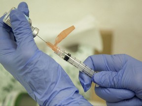 FILE - In this Aug. 27, 2010 file photo, a nurse practitioner prepares a flu vaccination in Rockville, Md. A puzzling study of U.S. pregnancies suggests that women who received back-to-back flu shots between 2010 and 2012 _ after a new swine flu vaccine came out _ more often had miscarriages. (AP Photo/Evan Vucci, File)