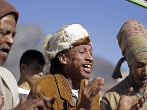 FILE - In this Thursday, June 28, 2012 file photo, men from the Khoisan ethnic group sing in Cape Town, South Africa, during an event unveiling a new suggested name by them for Cape Town, which translates as, "Where the clouds gather." The Khoisan gathering placed emphasis on there race and ethnicity in South Africa. In a paper released Thursday, Sept. 28, 2017 by the journal Science, Mattias Jakobsson of Uppsala University in Sweden and co-authors put the earliest split in Homo sapiens they could detect at 260,000 to 350,000 years ago. That's when ancestors of today's Khoisan peoples diverged from the ancestors of other people, they calculated. (AP Photo/Schalk van Zuydam)