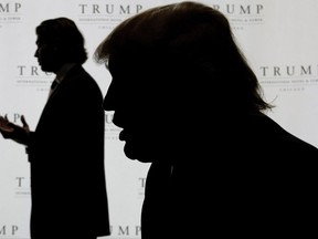 FILE - In this Sept. 24, 2008, file photo, Real estate developer Donald Trump, right, talks with The Associated Press as his son, Donald Jr., gives an interview, during topping off festivities for his 92-story Trump International Hotel and Tower in Chicago. The 39-year-old presidential namesake stepped into his most scrutinized role yet Thursday, Sept. 7, 2017, appearing before the Senate Judiciary Committee as lawmakers probe Russian meddling in the election that handed his father the White House.  (AP Photo/Charles Rex Arbogast, File)